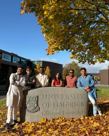 student by the University of Limerick stone in traditional clothing