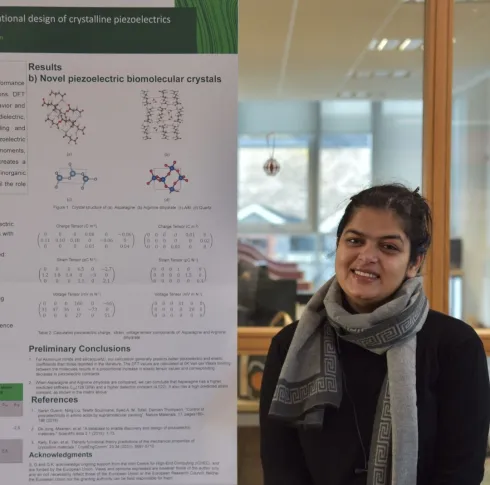 Bernal researcher stands in front of a research poster 