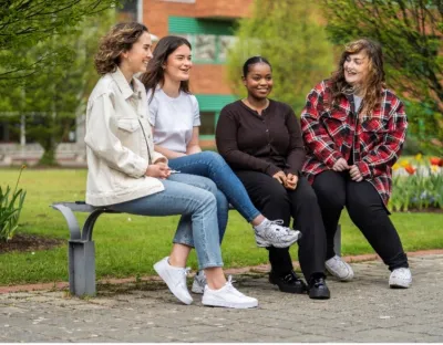 four UL students sit on a bench on the UL campus 