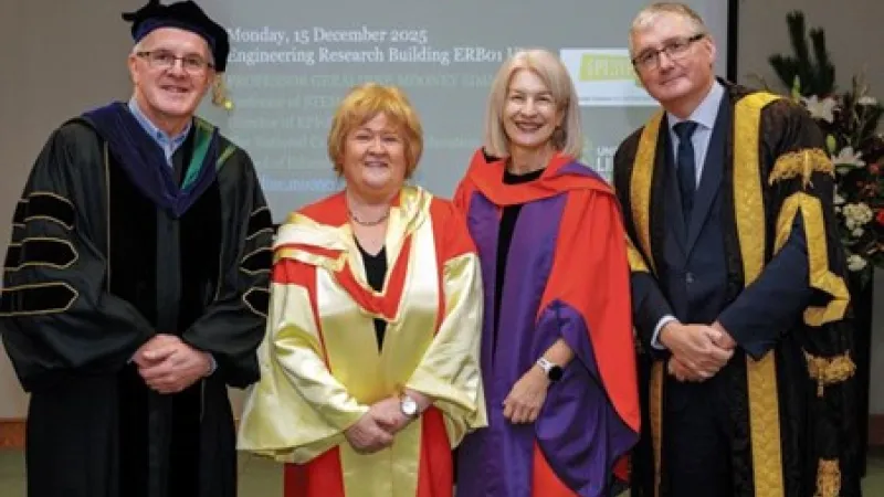 Four people in robes standing for a photo