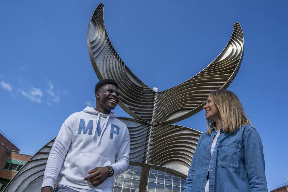 International students laughing beside Schumann building