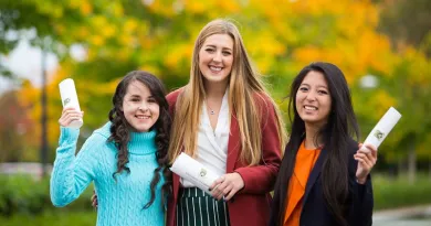 3 ladies smiling holding parchments