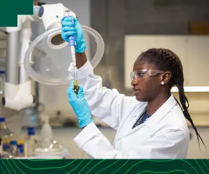 science student in lab coat  working on research in UL