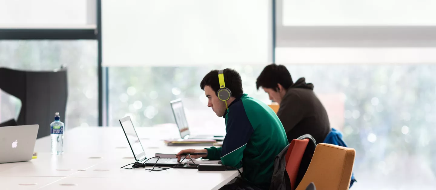 Image of two students on laptops in UL Library