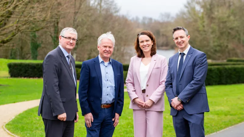 Image of four people standing in outdoor setting 