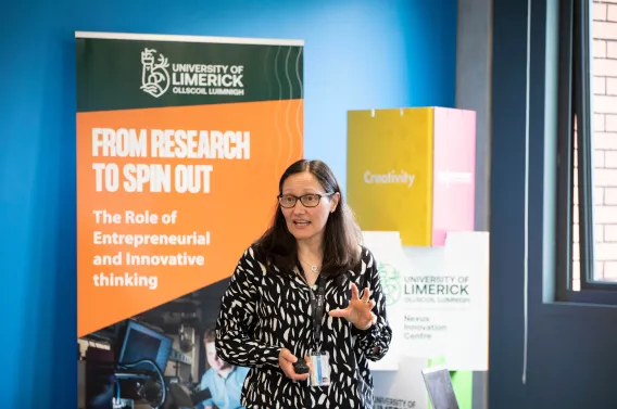 Black haired woman speaking in front of pull ups