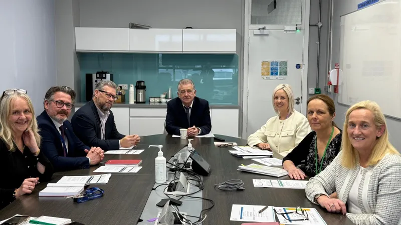 Photo of seven people in a meeting around a table